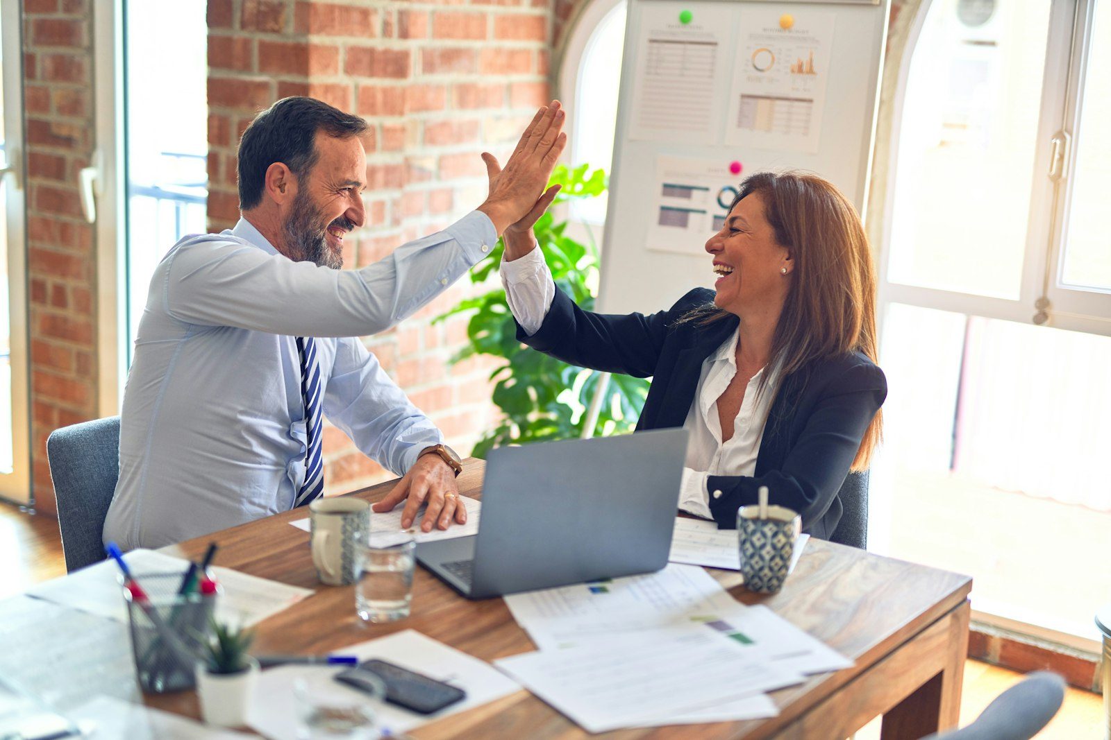 Two colleagues celebrating at a desk