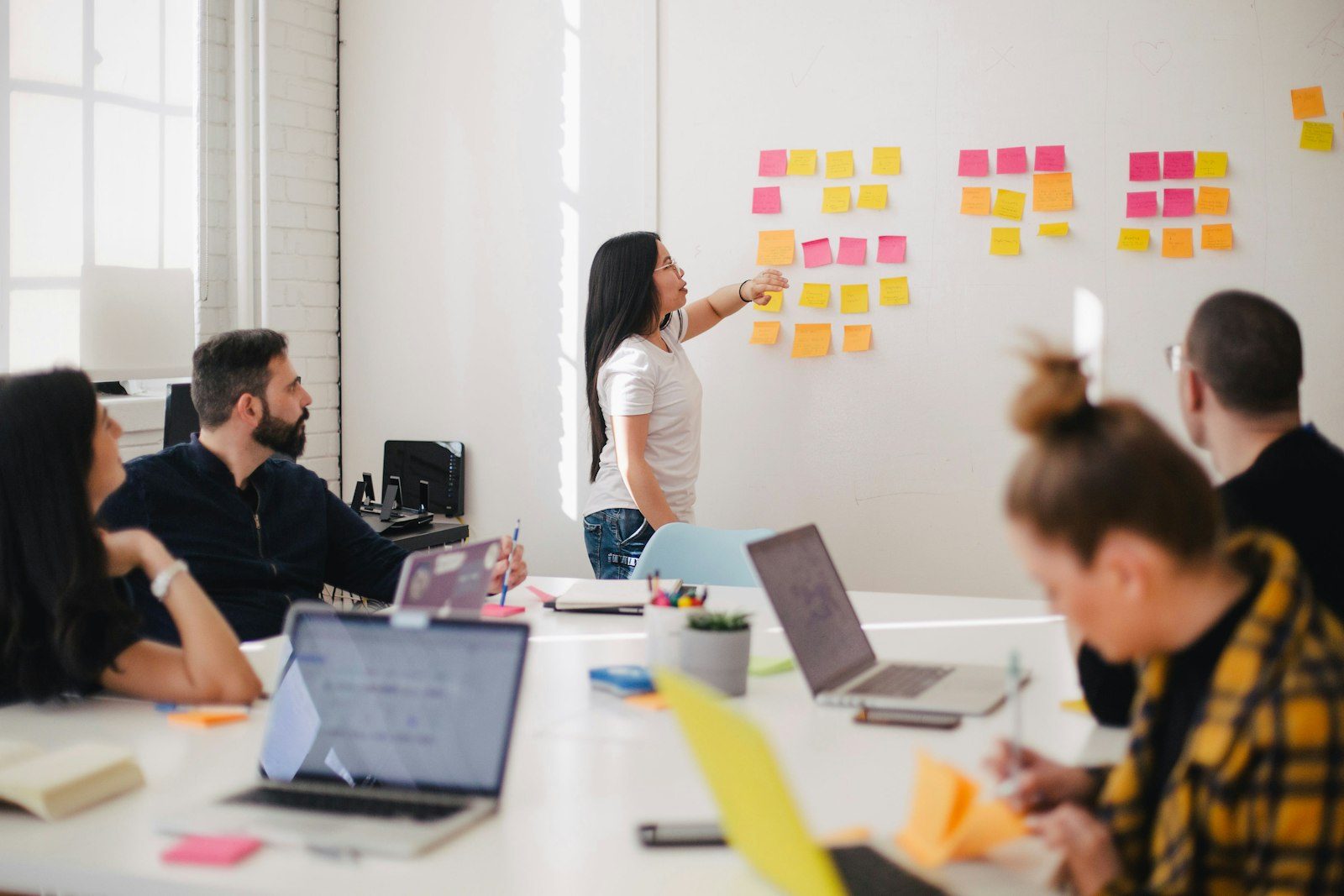 A team reworking a plan on a wall of sticky notes